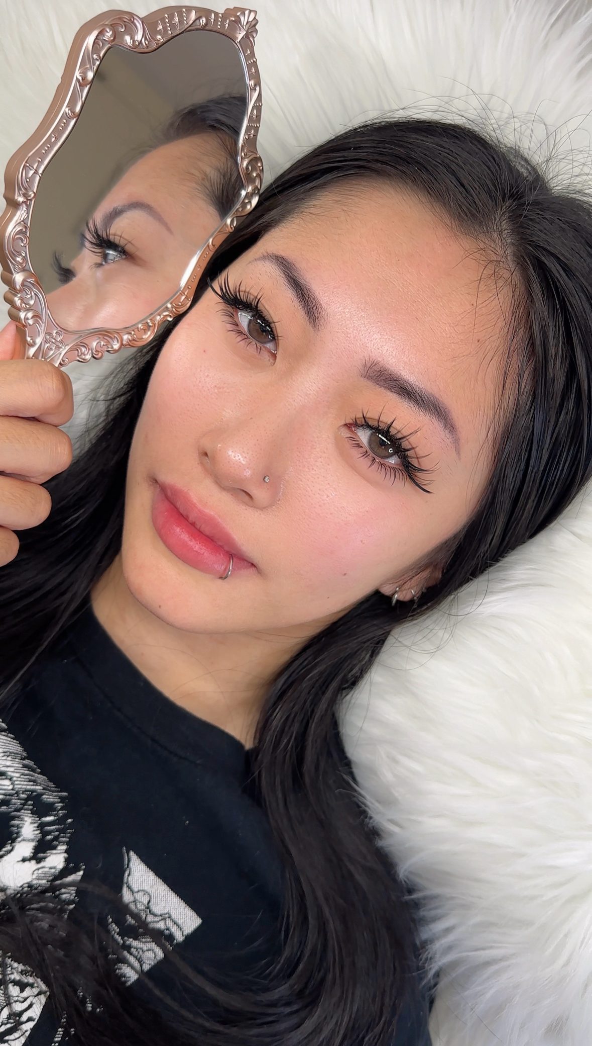 A Cilesia Beauty Bar client admiring her custom anime lashes in a hand mirror, Legacy East, Plano